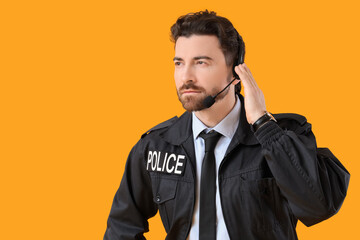 Male police officer  in headset on yellow background