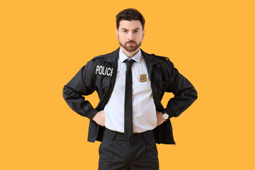 Male police officer with badge on yellow background