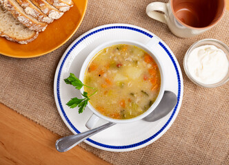 Soup with barley and pickled cucumbers, pearl barley, meat, carrots and potatoes served with bread.