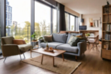 Blurred view of modern living room with sofa and soft bench. room interior with couch, armchair and coffee table or shelving units. stylish living room. comfortable workplace near big window.