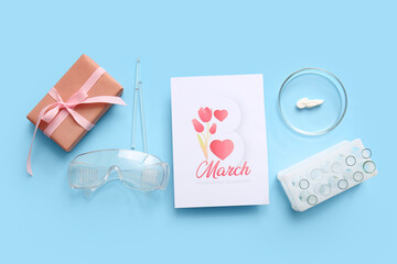 Fototapeta premium Professional laboratory tools with greeting card and gift box on blue background. International Women's Day celebration