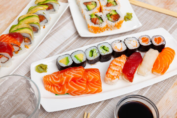 Different types of sushi and sashimi served with soy sauce and chopsticks.