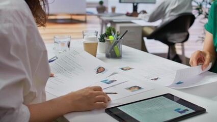 Team of recruiters selecting candidates based on their resumes, looking for the right person to fill in job vacancy. HR staff evaluating the qualifications of applicants after interview. Camera B.