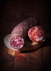 Cured sausage resting on wooden cutting board, a culinary delight