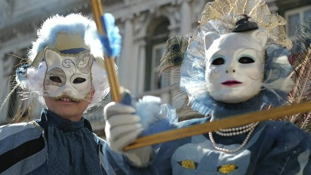 Venice, Italy - People dressed in carnival masks are photographed by tourists in the scenery of the ancient Venetian palaces