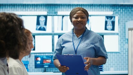 Obraz premium Medical team reviewing diagnostic x rays in a healthcare facility, focusing on disease prevention and early virus detection to provide treatment care. Licensed doctors consulting results. Camera B.