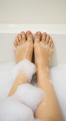 Fototapeta premium Relaxing Bath, Bubbly Soaking, Woman's Legs in Foamy Water, Spa Treatment, Self-Care Ritual, Cleanliness, Hygiene, Pampering, Tranquility, Soft Skin