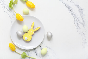 Beautiful table setting with Easter eggs, bunny and yellow tulip flowers on white background