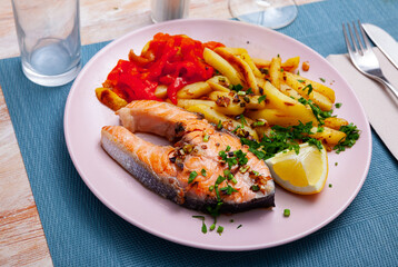 Spanish cuisine, roasted seafood salmon with fried potato and pepper on a ceramic plate