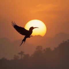 Naklejka premium Majestic Bird Silhouette at Sunset Flying against Vibrant Orange Sky