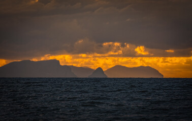 Picturesque view to a sunset sea gulf with beautiful mountains and amazing cloudy sky on background of nice travel landscape. Sicily, Campofelice di Roccella. August 2024