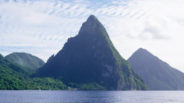 Ocean view of the iconic Twin Pitons, rising sharply from the sea under a patterned sky in Saint Lucia.