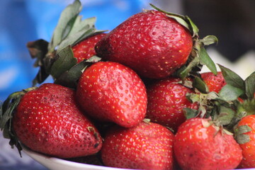 A close-up of fresh strawberries with green leaves