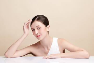 Fototapeta premium Beautiful young woman with clean fresh skin on beige background, Face care, Facial treatment, Cosmetology, beauty and spa, women portrait.