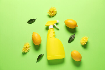 Spray bottle of cleaning product, flowers and lemons on green background, flat lay