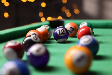 Many colorful billiard balls on green table indoors, closeup
