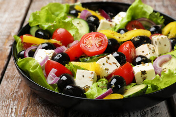 Delicious fresh Greek salad on wooden table, closeup