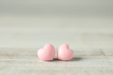 Pink decorative hearts on white wooden table, space for text. Happy Valentine's day