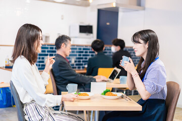 オフィスのカフェテリアのランチを食べる社員