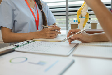 two doctors are meeting to exchange new knowledge and information they have gained form their medical seminars with each other, a senior doctor is explaining information and knowledge