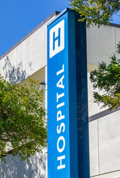A modern hospital building showcasing a prominent blue sign with the letter H, symbolizing healthcare and emergency services, making it a recognizable and essential medical facility.