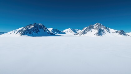 Fototapeta premium Beauty in nature landscape concept. Snow-covered mountains under a clear blue sky create a serene winter landscape.