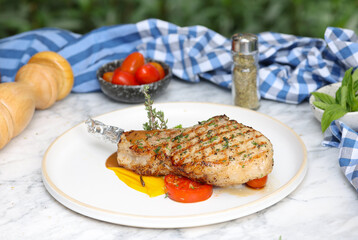 Grilled pork chop with vegetables outdoor dining food photography natural light culinary art