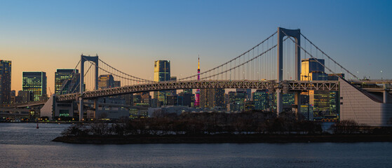 Landscape view of Tokyo skyline and rainbow bridge at sunset to night. Tokyo, Japan.