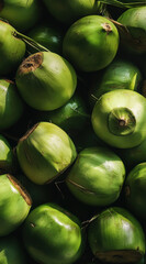 Fresh green and yellow coconuts at the market with tropical fruits and organic produce