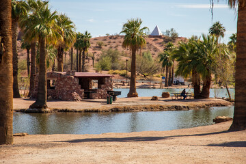 A gorgeous landscape at Papago Park with a lake, lush green palm trees and rocks in Phoenix Arizona USA