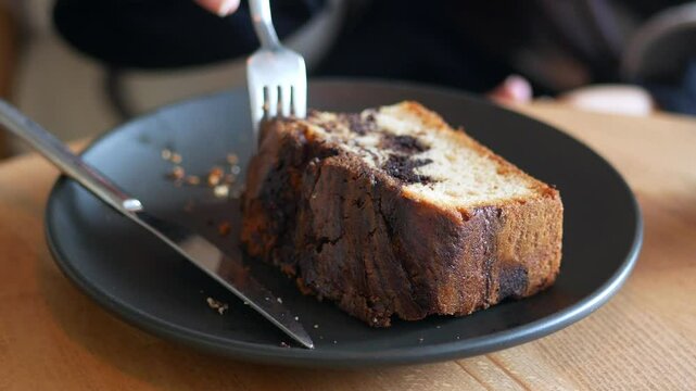 Enjoying a slice of chocolate marble cake at a cozy cafe