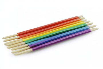 Fototapeta premium Colorful rainbow spectrum of wooden sticks arranged on white background creating a vibrant and cheerful mood for artistic projects