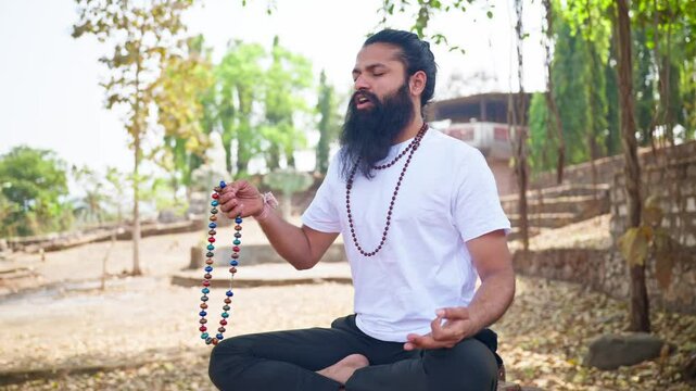 Bearded man meditates beneath trees at retreat