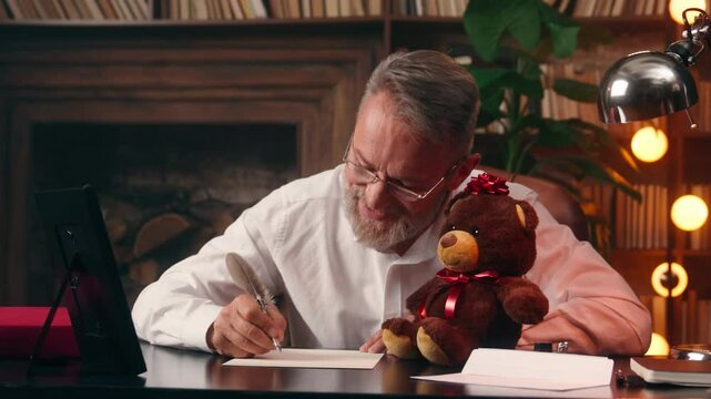 Old Caucasian man grandfather writing send letter grandson granddaughter grandchildren family smiling male pensioner looking framed photo happy businessman write business home office indoors message