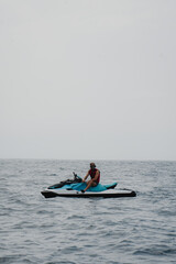 Adventurer on a Jet Ski Floating in the Open Sea with a Mask and Life Vest