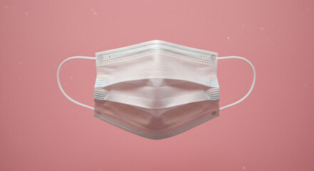 A close-up image of a disposable surgical face mask with elastic ear loops, set against a vibrant pink background with subtle light effects.