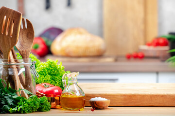 Healthy vegan eating, cooking, food blogging background. Oak cutting board and bread, herbs, vegetables on cozy kitchen with wooden table, kitchenware and utensils