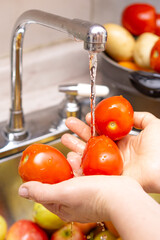 Woman washing organic tomatoes, food disinfection concept