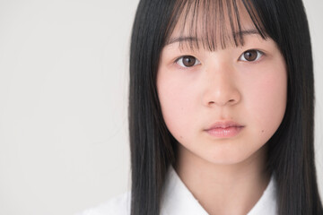 日本人の女の子の顔。スタジオ撮影白背景。