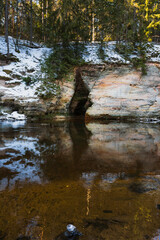 Sandstone winter landscape: river, Virgin's Cave, and snow in Taevaskoja, Estonia.