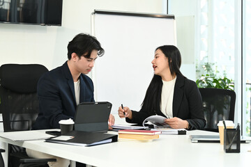 Photo of young office workers working together at the working desk with a computer laptop and digital tablet.