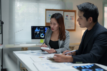 Business colleagues analyzing financial charts and data in office meeting