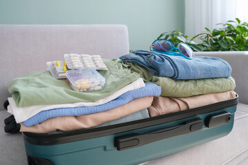 Clothes and pills in a travel bag. Concept of medication required in journey