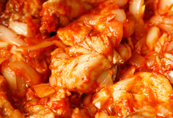 A close up of a dish of meat with onions and tomatoes