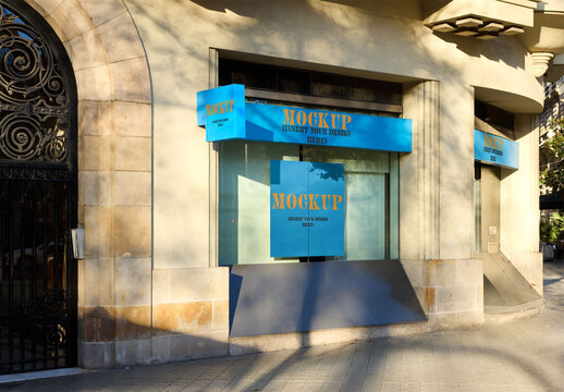 Sunny Barcelona business retail Storefront With hang sign and poster.