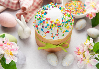 Easter cake decorated with colorful sprinkles, eggs and spring flowers