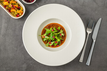 Purslane salad with olive oil and pomegranate in a white porcelain plate