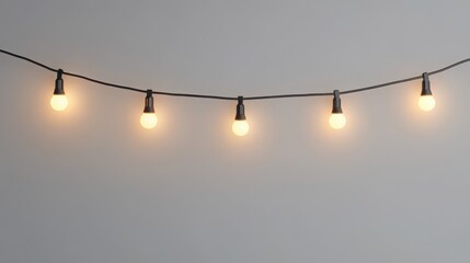 String lights with glowing bulbs on gray background