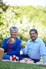 Love, portrait and picnic with old couple in nature for fruit juice, happiness and anniversary date. Health, peace and bonding with senior man and woman in park for food, relax or retirement together