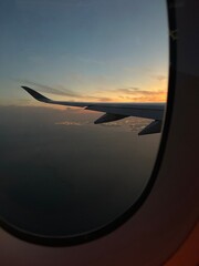 Airplane window view of sunset overlooking Doha, Qatar